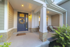 Front and sidelight of home with front porch and wood siding exetrior wall