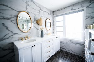 Marble wall print and gold accessories in bathroom