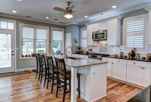 Updated kitchen with wood floors, white cabinets, an island, and modern appliances