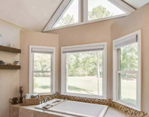 three large, attractive windows overlooking a scenic yard